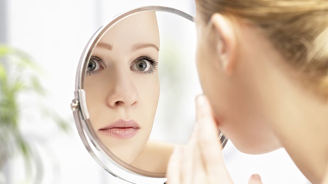 woman applying make up in mirror